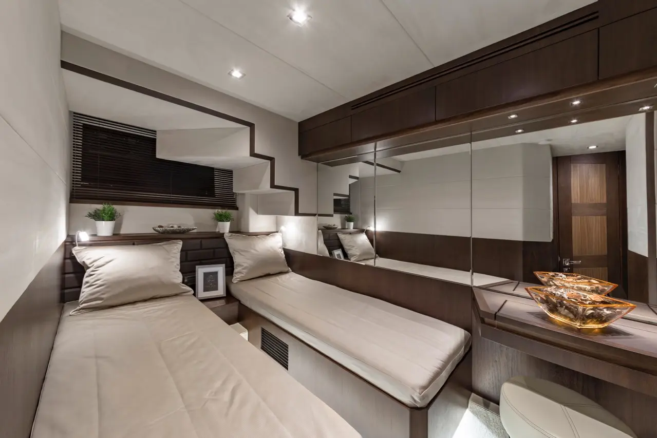 Elegant modern bedroom with mirrored walls, two beds, plants, and ambient lighting, featuring decorative glass bowls on a dresser.