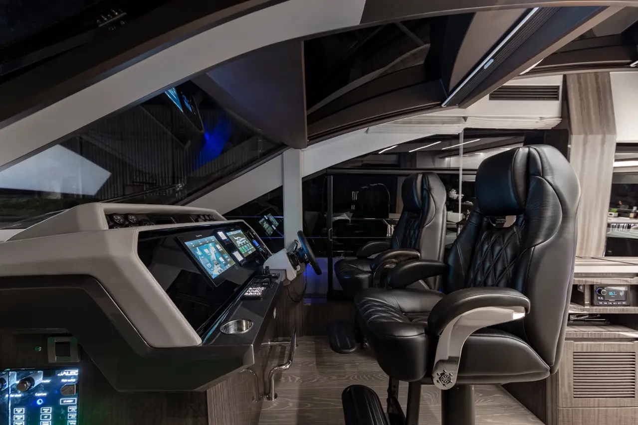 Sleek modern cockpit featuring two black leather pilot chairs and digital control panels with navigation displays.