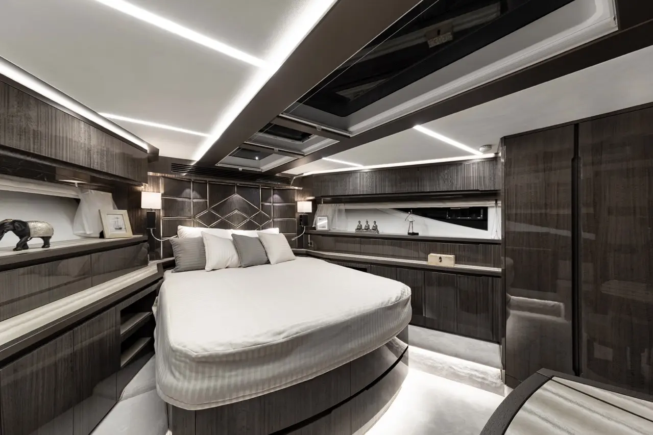 Modern yacht interior featuring a round bed, stylish wood finish, wall decor, and soft lighting. Elegant and spacious design.