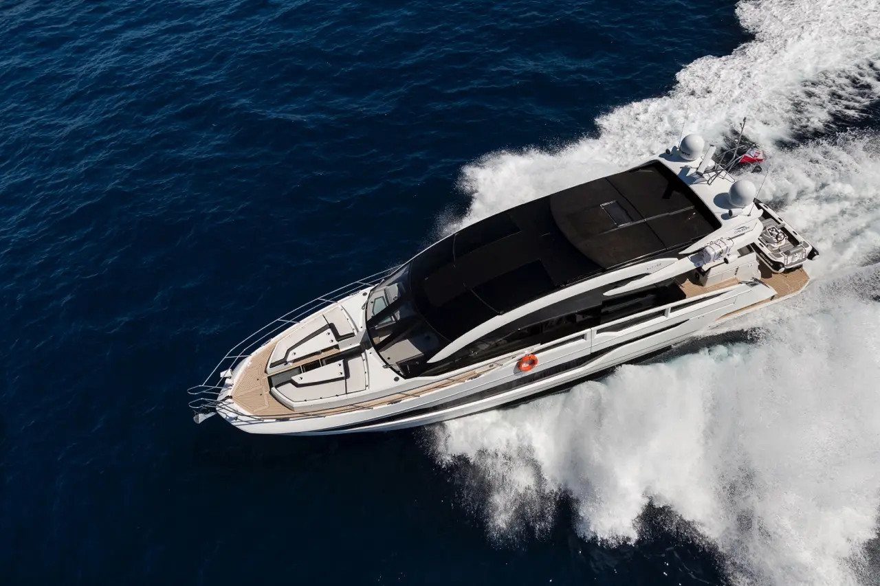 A luxury yacht cruises through deep blue waters, leaving a wake behind, showcasing its sleek design and modern features.