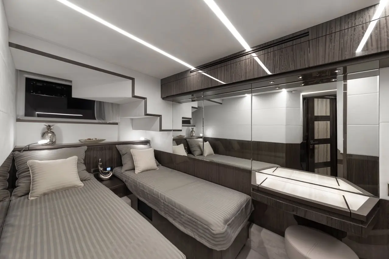 Modern bedroom design featuring two single beds, sleek dark wood finishes, mirrors, and stylish lighting.