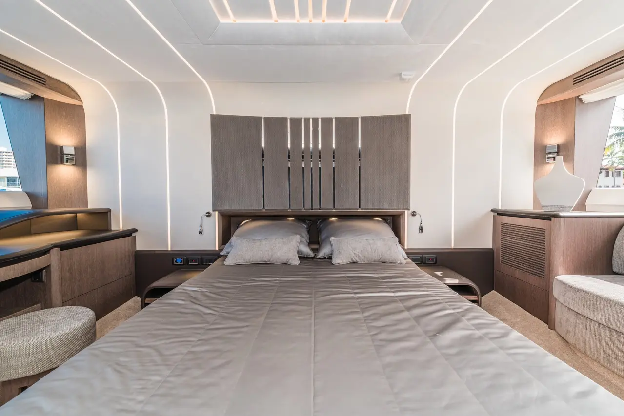 Sleek modern bedroom featuring a grey upholstered headboard, two pillows, and ambient lighting with warm tones.