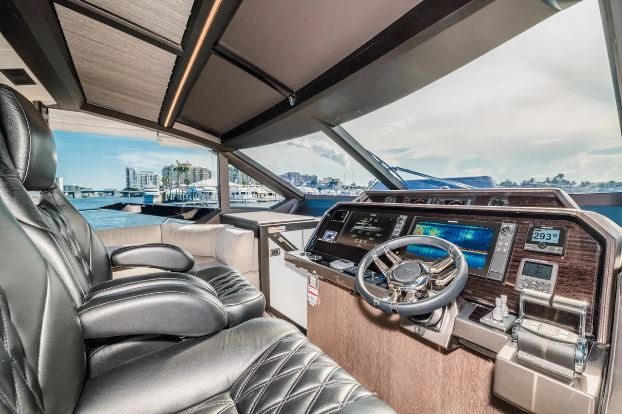 Luxury yacht cockpit featuring leather seats, a panoramic view, and advanced navigation screens. Visible text shows 
