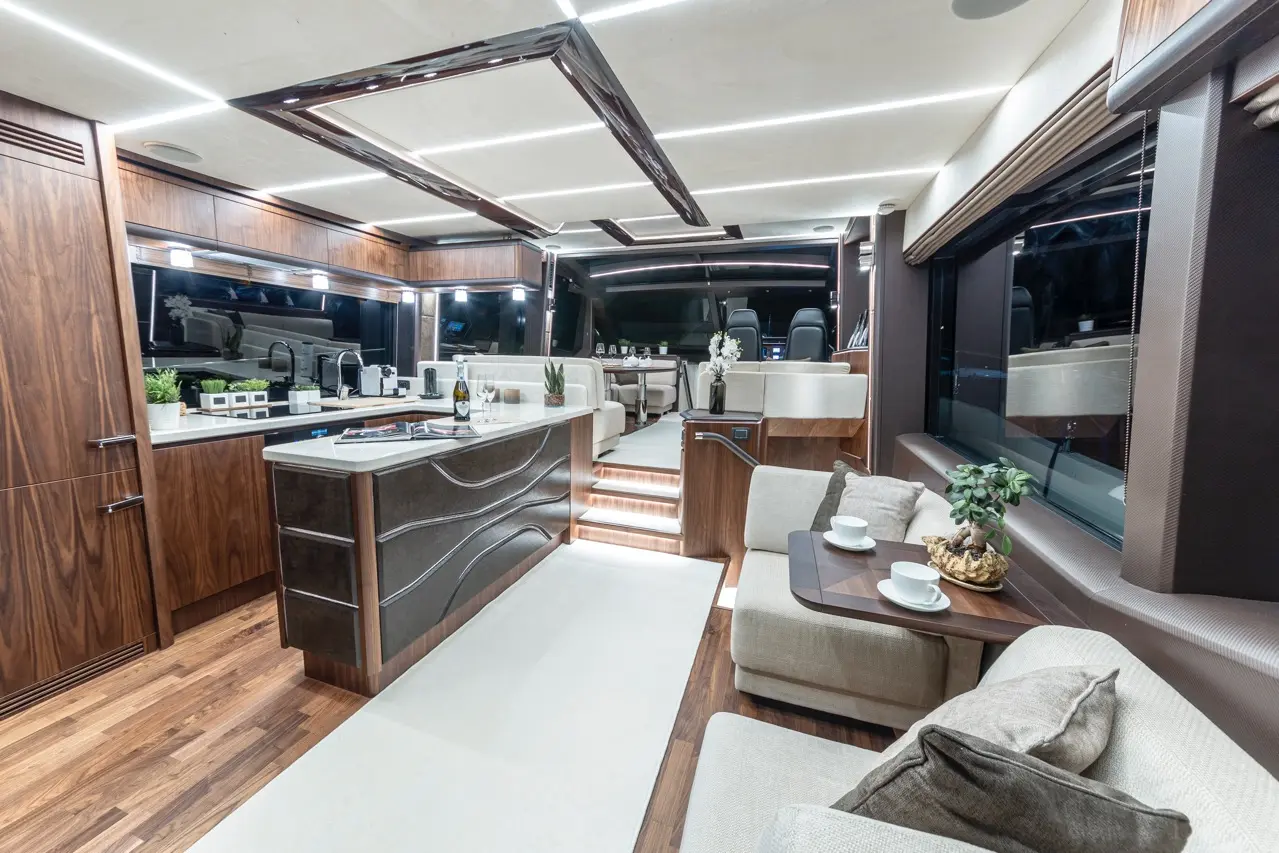 Luxurious boat interior featuring a modern kitchen, dining area, and cozy lounge with plants and elegant furniture.