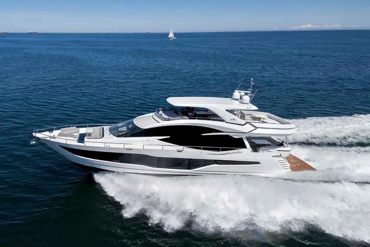 A luxurious white yacht cruises over blue waters, leaving a wake, with a sailboat visible in the background.
