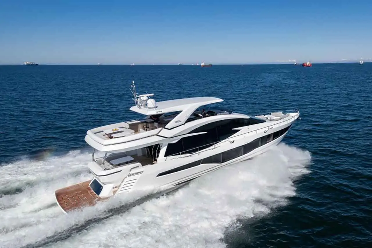 A sleek luxury yacht gliding across blue waters, leaving white foam trails, under a clear sky with distant ships.