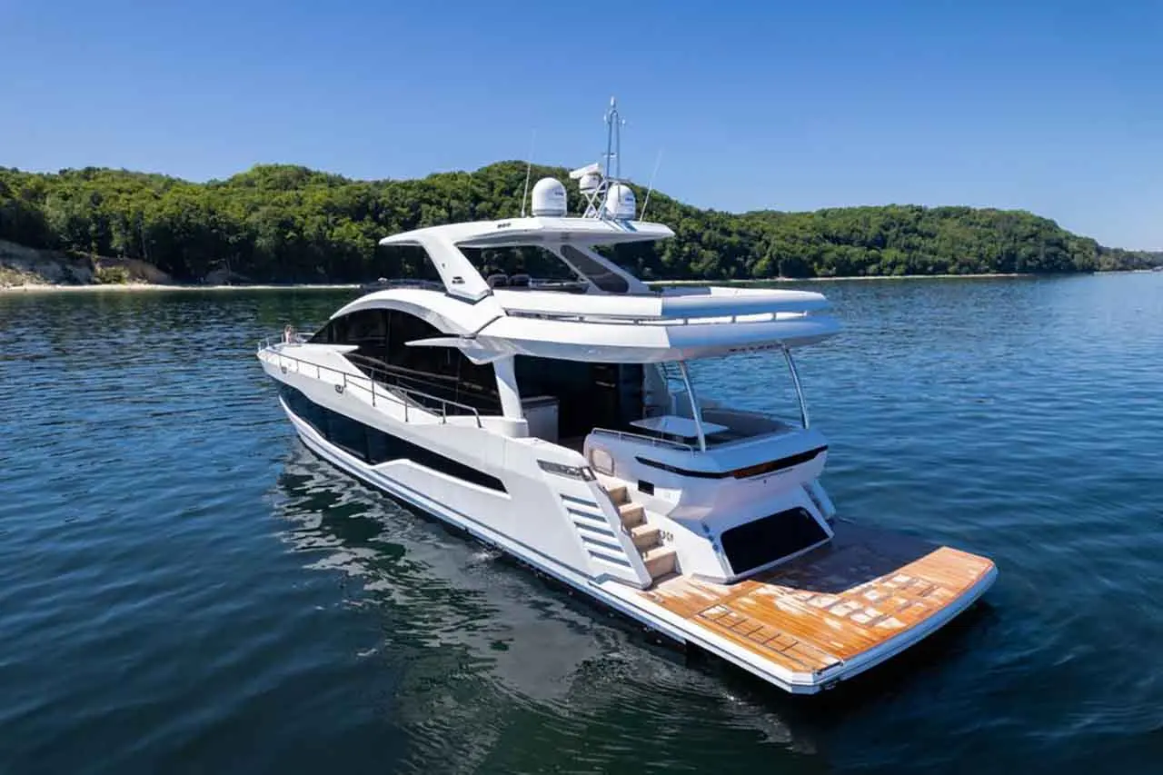 Luxury yacht on serene waters with greenery in the background, showcasing modern design and stylish outdoor deck.