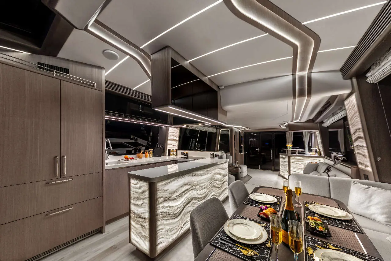 Luxurious yacht interior featuring a dining table set with dishes, champagne glasses, and stylish furnishings against a modern kitchen.