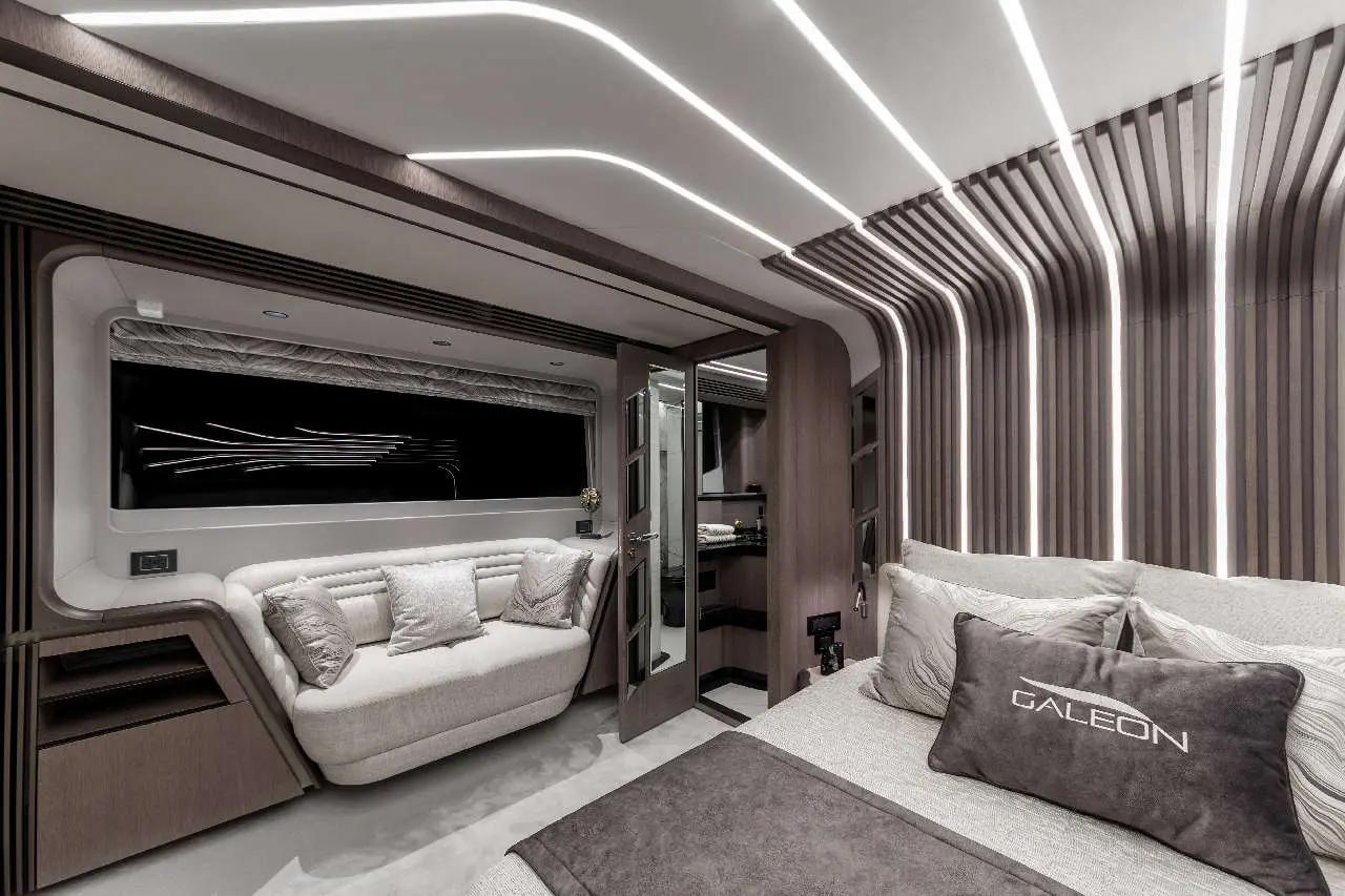 Stylish interior of a yacht cabin featuring plush seating, modern lighting, and a cushion with 'GALEON' text prominently displayed.