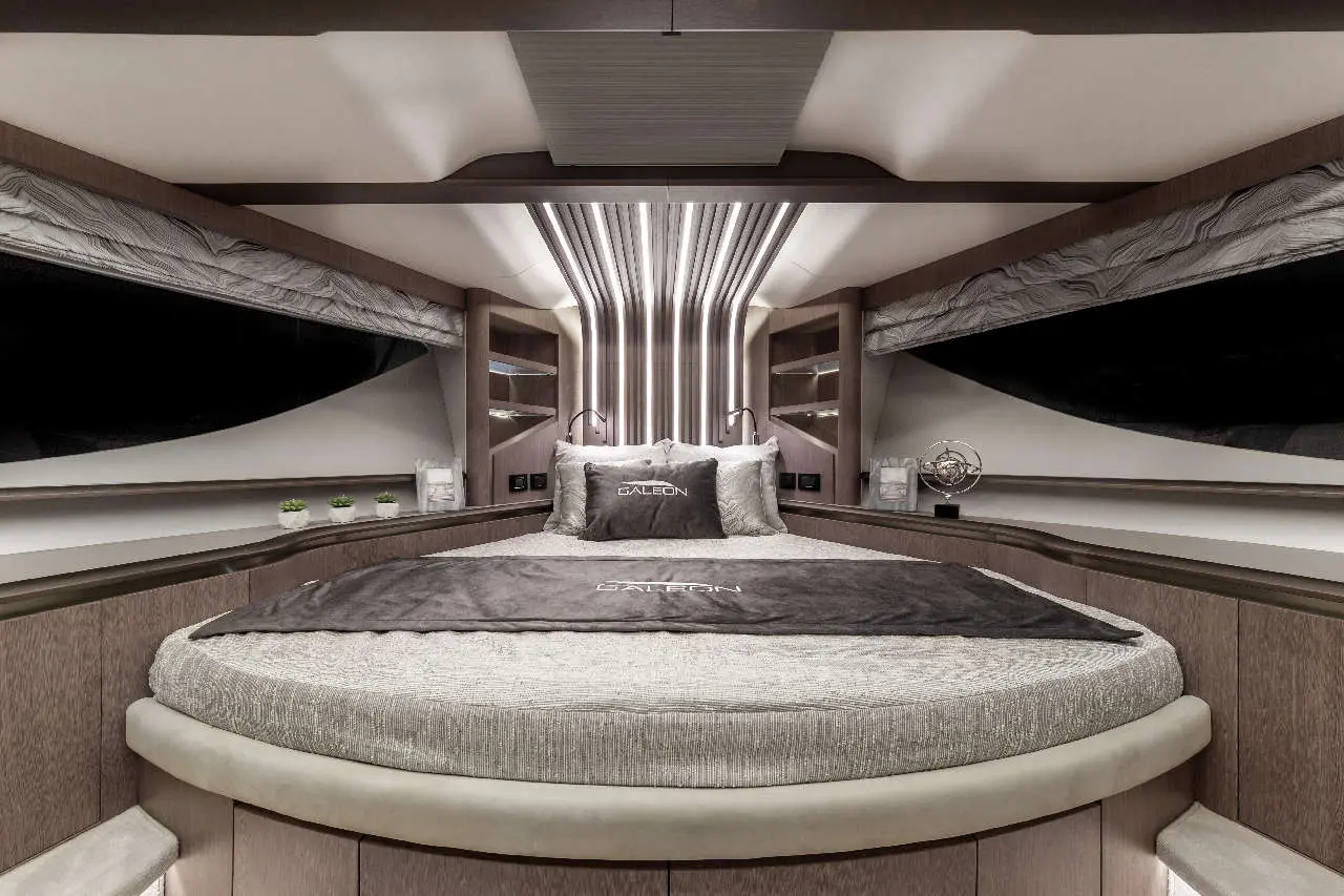 Luxury yacht interior featuring a round bed, elegant decor, and the word 