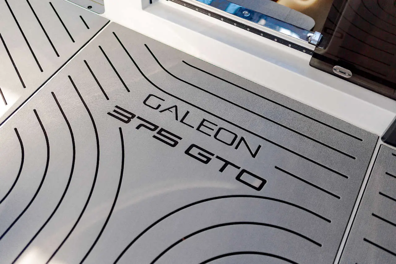 Galeon 325 GTO logo displayed on a patterned surface, highlighting modern boat design and craftsmanship.