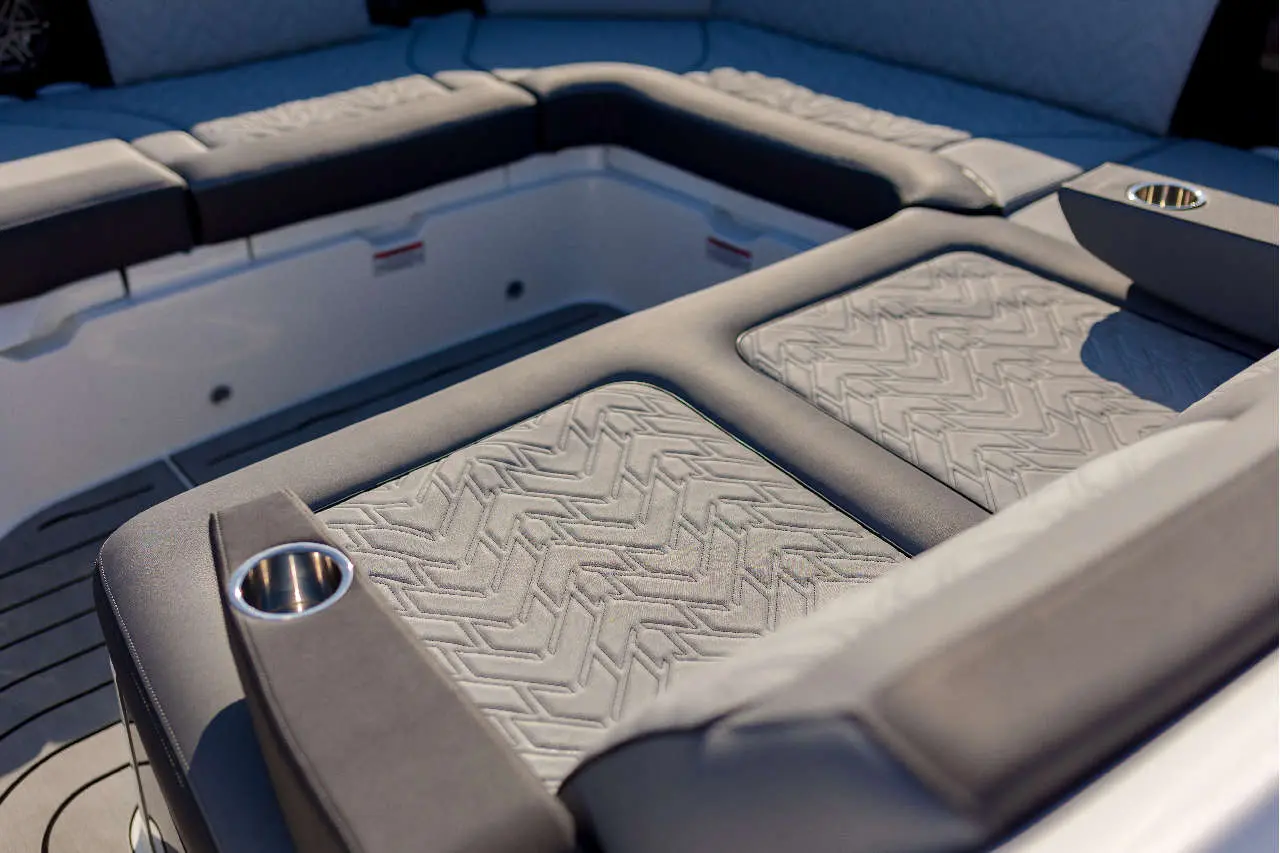 Luxurious boat seating featuring textured grey upholstery and integrated cup holders, set against a light-coloured backdrop.