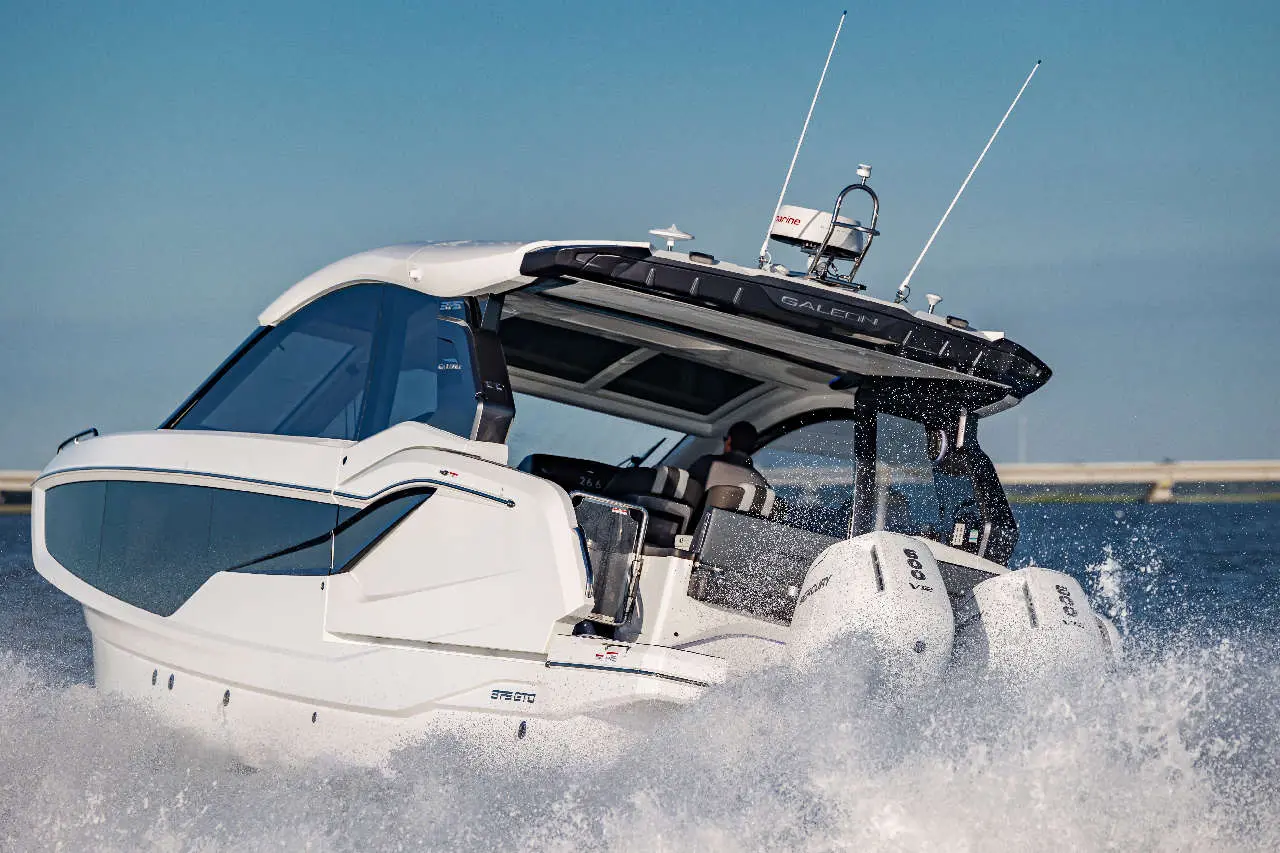 A sleek white boat with a canopy accelerates across water, creating splashes, showcasing modern marine design and technology.