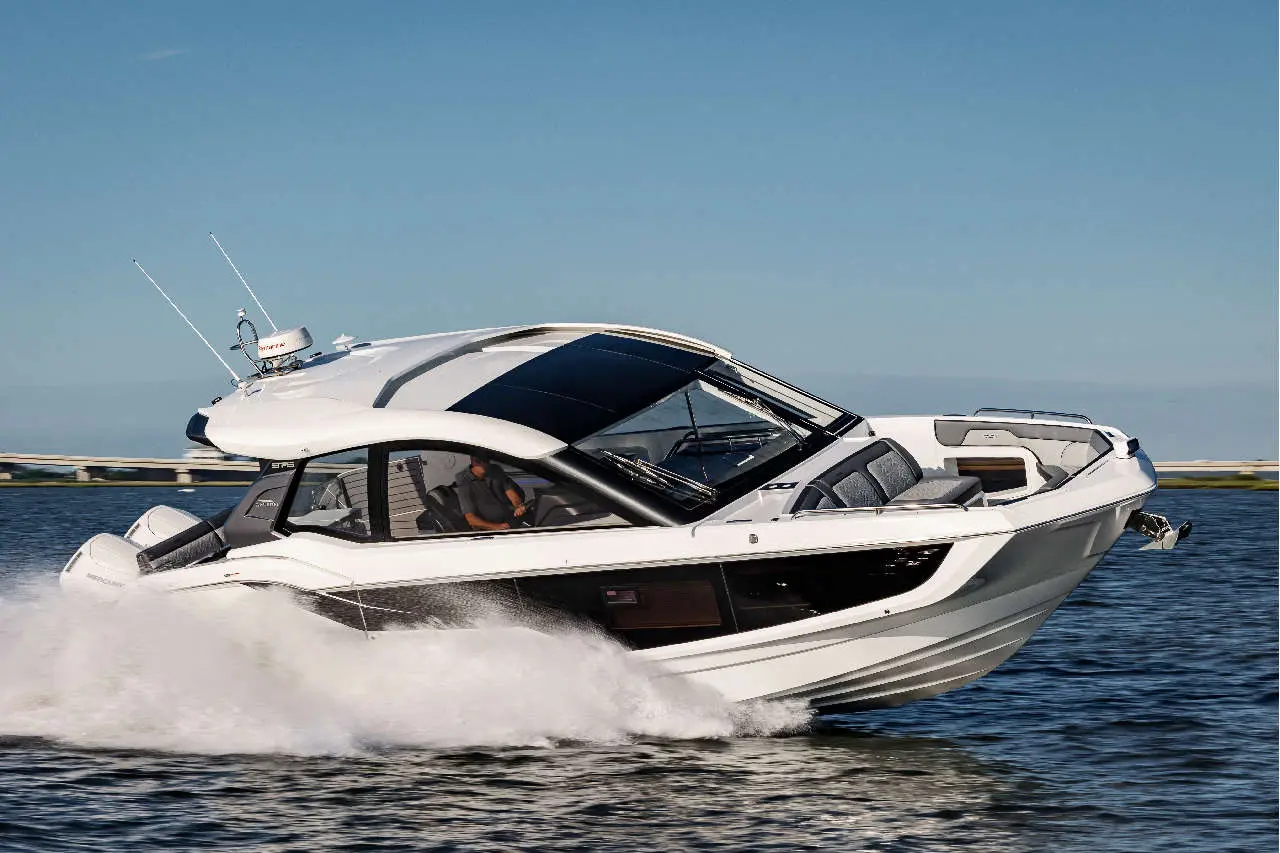 A sleek white motorboat navigating swiftly on water, with a person piloting it and splashes of water trailing behind.