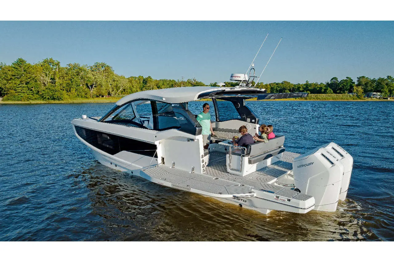Family on a modern motorboat enjoying leisure time on the water; lush greenery visible in the background.
