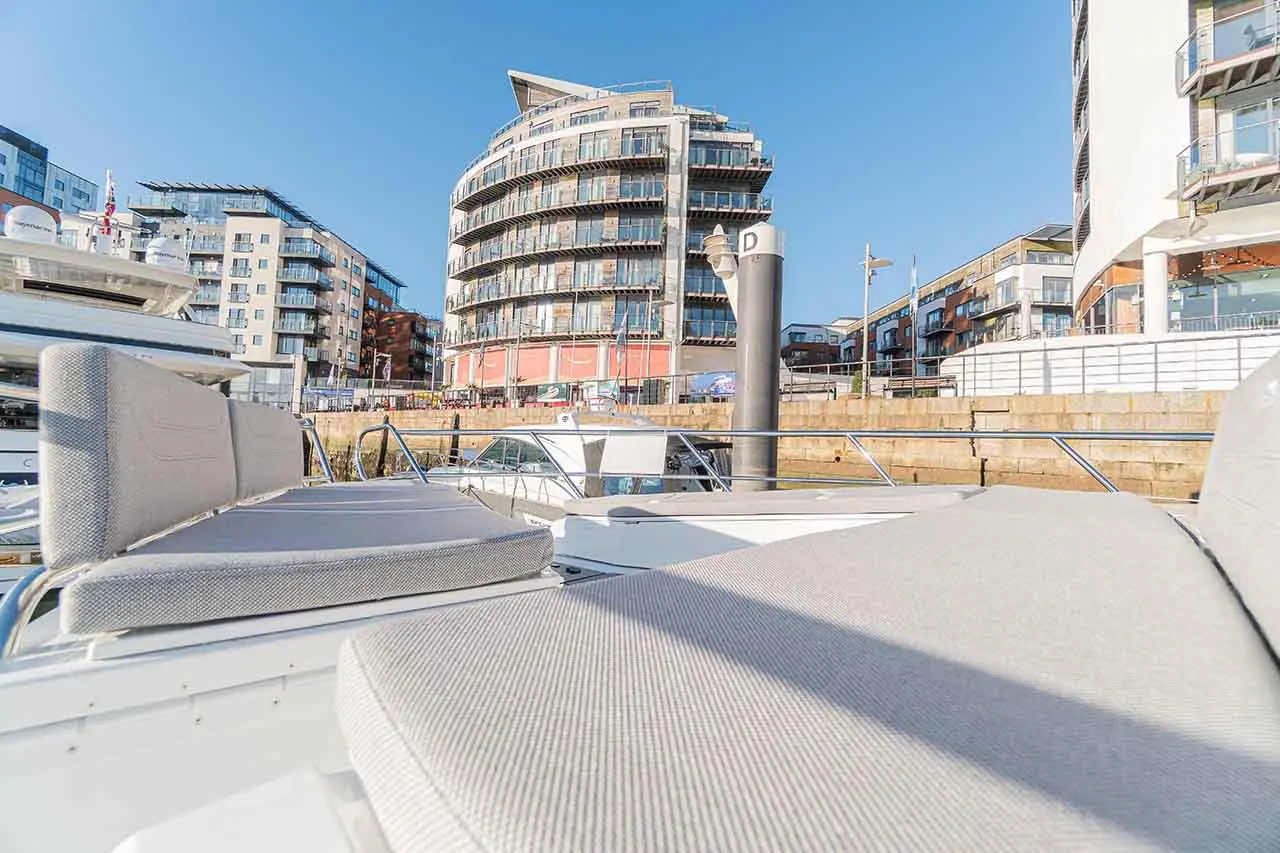 View from a boat showing modern waterfront apartments and a clear blue sky over a vibrant marina.