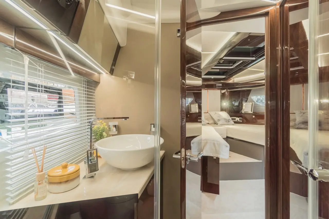 Luxurious bathroom with a stylish round basin, modern decor, and an inviting bedroom visible in the background.