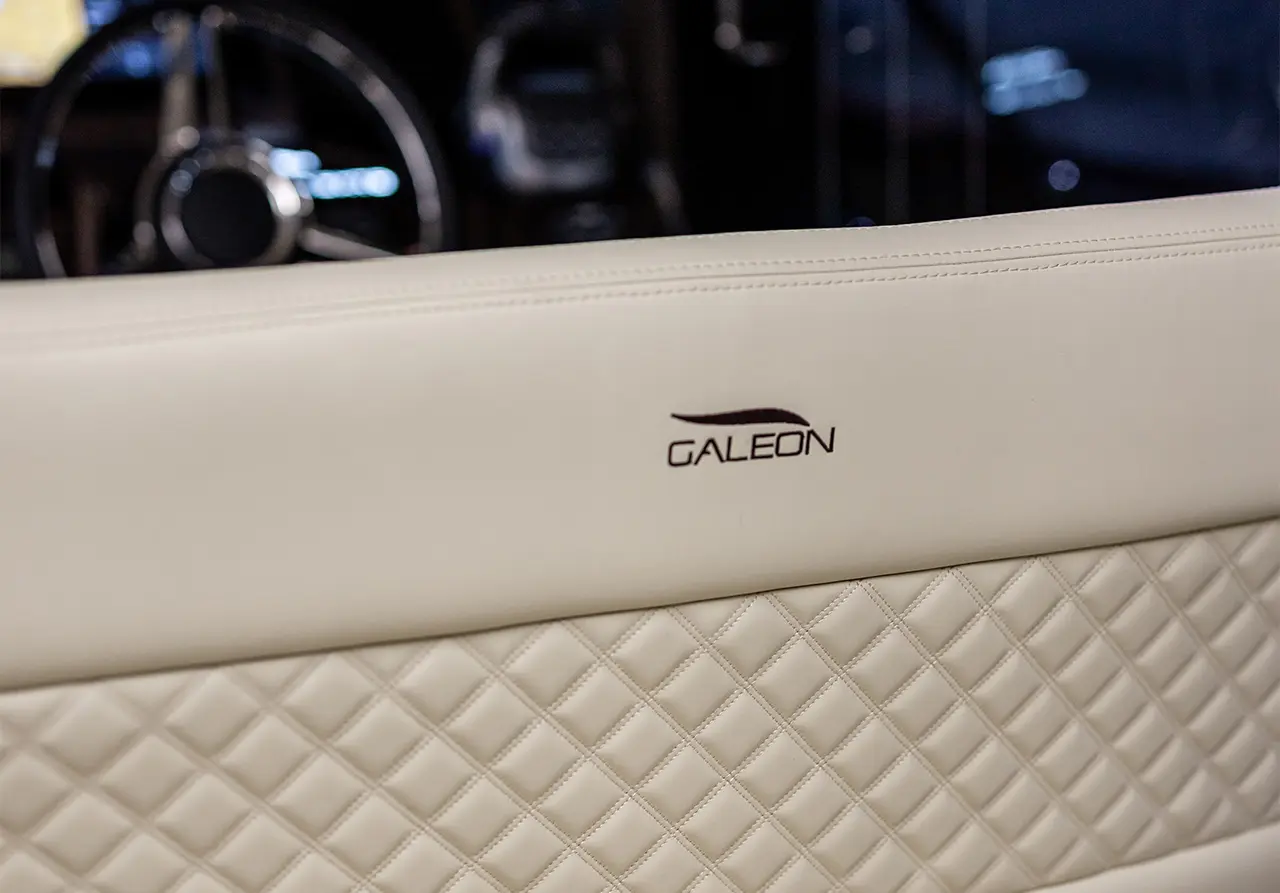 Close-up of a beige leather seat with diamond stitching, featuring the 