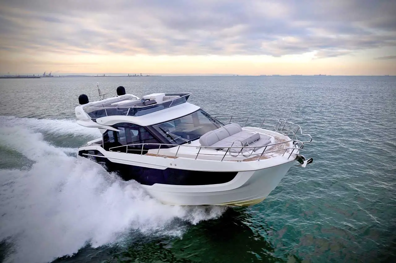 Luxury motorboat navigating through calm waters with grey clouds in the background, showcasing modern design and comfort.