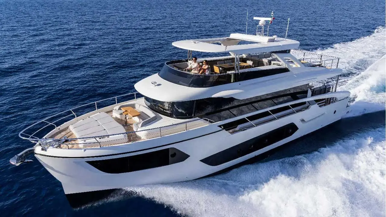 Luxury white motor yacht cruising through deep blue sea with passengers aboard and waves breaking behind.