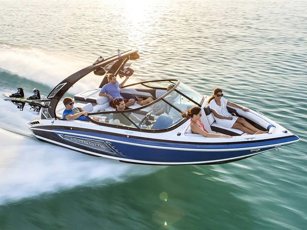 A group of five people enjoying a speedboat ride on water, with water skiing equipment attached to the boat.