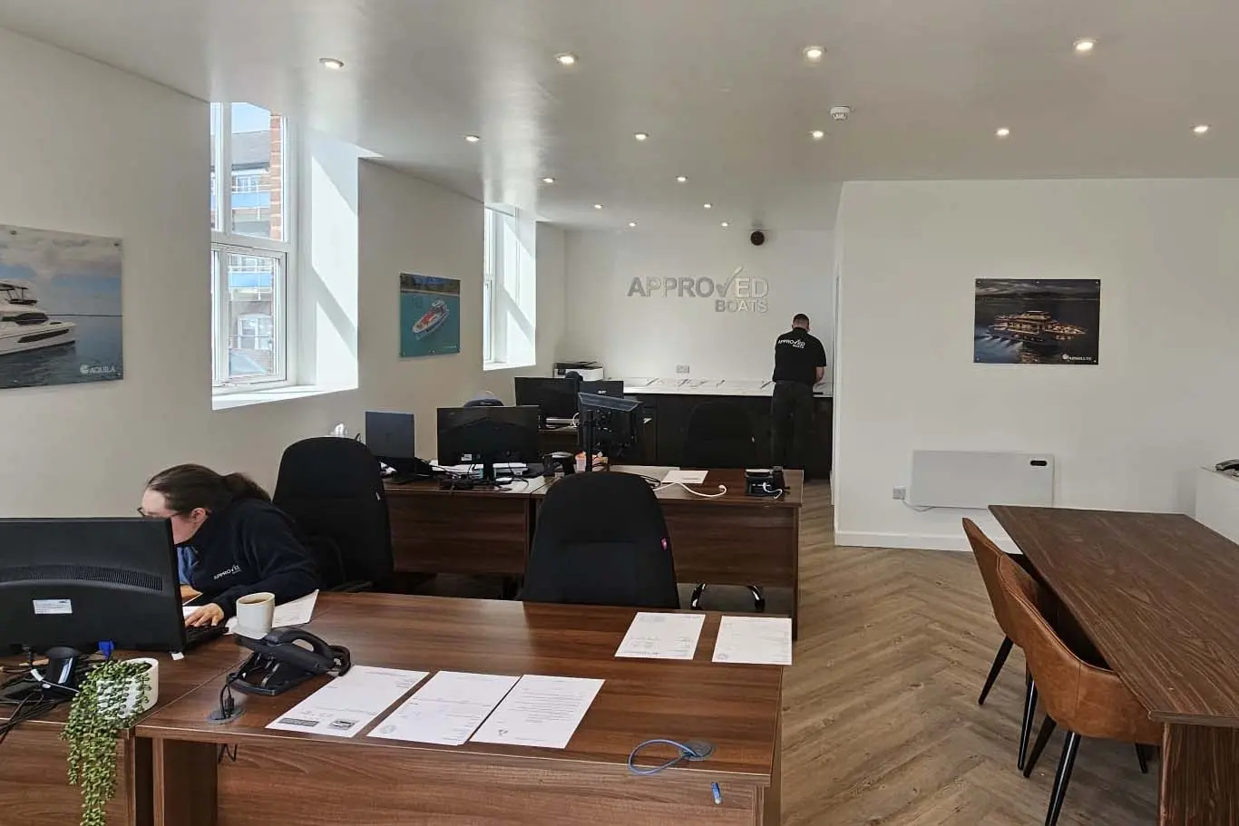 An office space with desks, computers, and a wall sign saying 