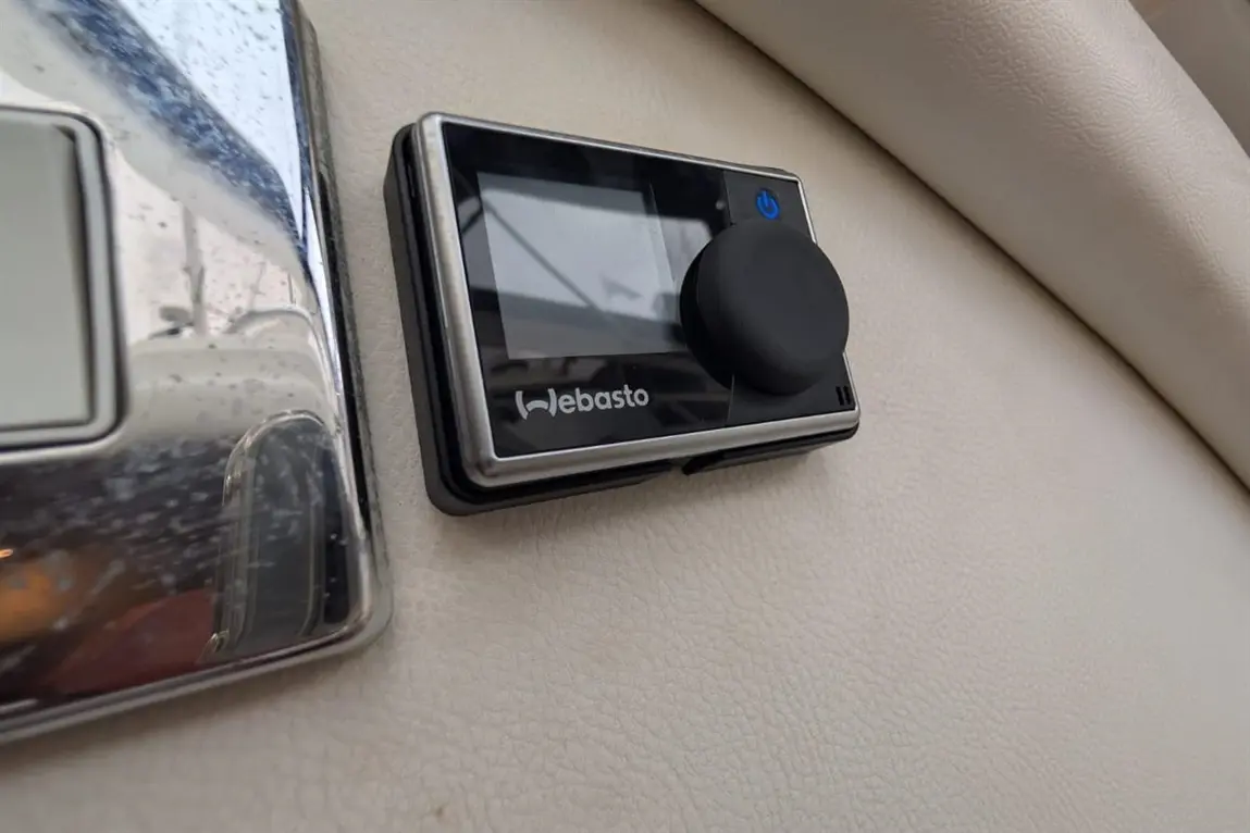 Webasto control panel mounted on beige surface, featuring a display screen and a prominent black knob for adjustments.
