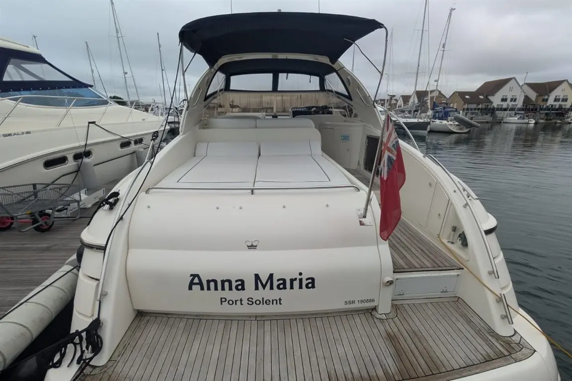 A white boat named "Anna Maria" is docked at Port Solent, displaying a British flag and surrounded by moored vessels.