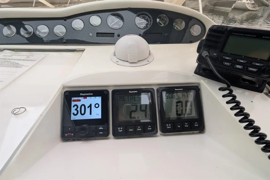 Dashboard of a boat featuring Raymarine displays showing compass heading 301°, depth 2.4m, and speed 0 knots.