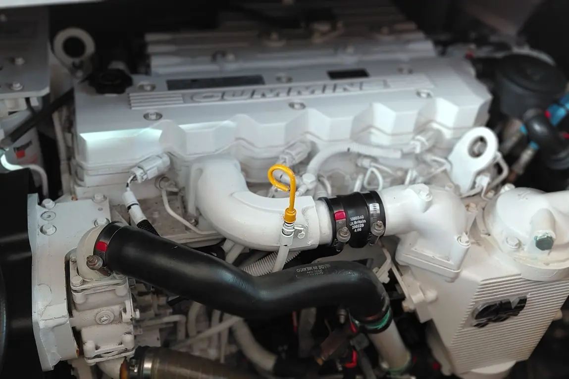 Engine components showcase a Cummins engine with a yellow dipstick and various pipes, highlighting maintenance access and design.