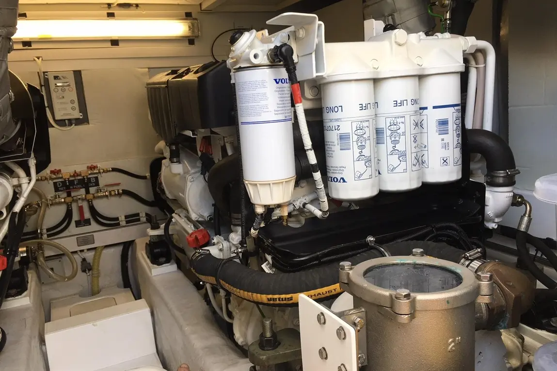 Marine engine compartment featuring Volvo components, fuel filters, and hoses, showcasing mechanical setup and equipment maintenance.