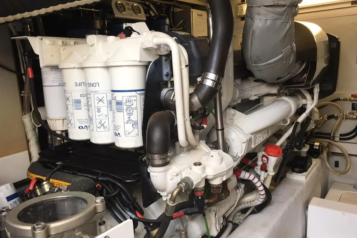 Marine engine compartment featuring Volvo filters, pipes, and gauges, illustrating a detailed vessel maintenance setup.