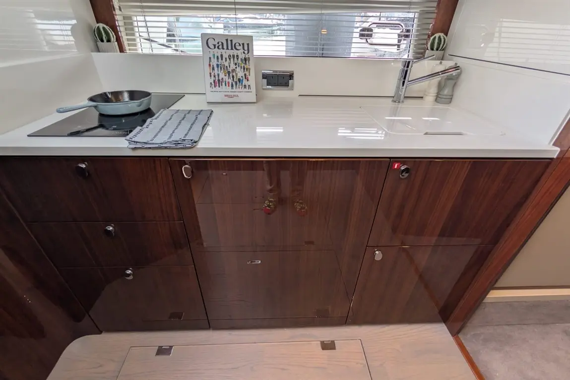 Modern galley kitchen featuring a cooking pan, countertop, and storage cabinets with a cookbook titled "Galley.