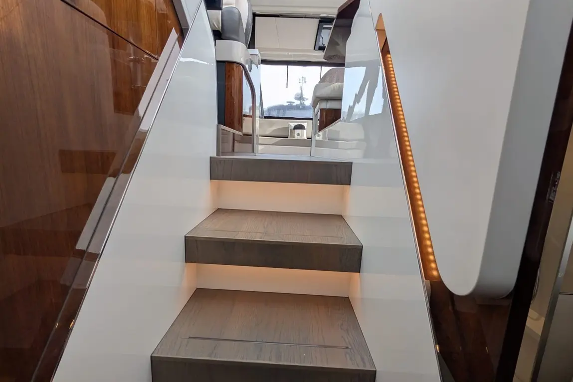 Modern boat stairs with wooden steps and ambient lighting, leading to a stylish interior space.