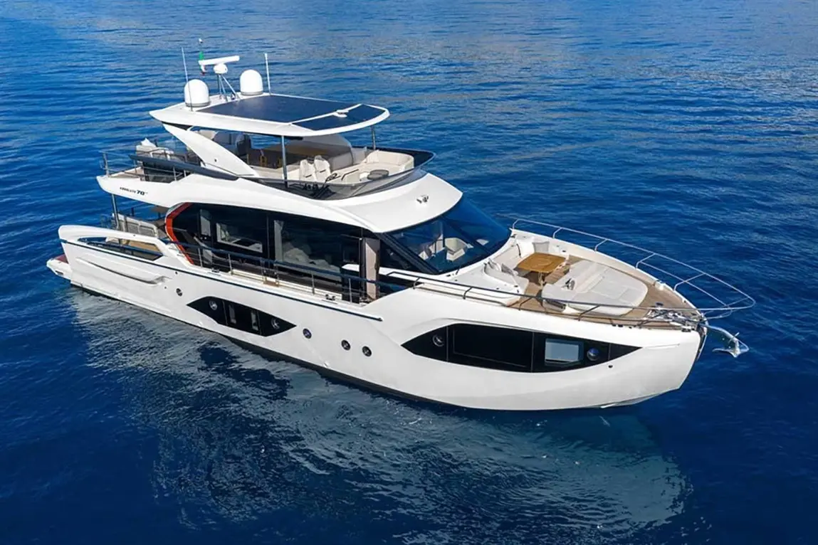 Luxury yacht sailing on calm blue waters, featuring a spacious upper deck and solar panels for energy efficiency.