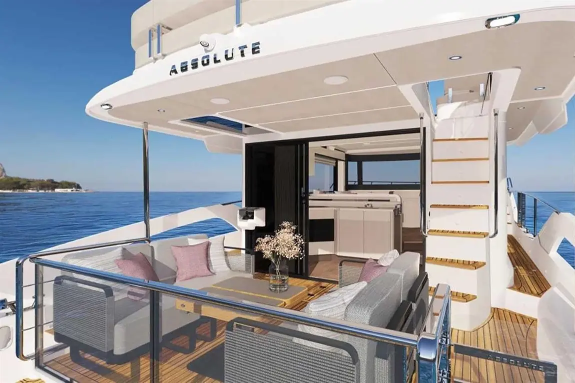 Luxurious yacht deck featuring seating, a table, and a staircase, with ocean views and the 'ABSOLUTE' logo visible.