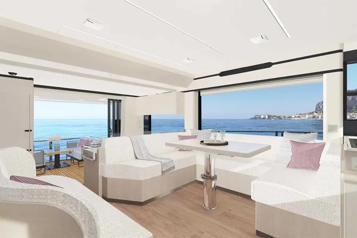Modern yacht interior with a spacious lounge area, minimalist design, and panoramic sea views through large windows.