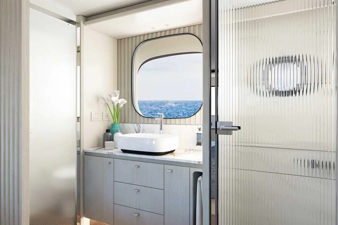 Modern bathroom featuring a basin, decorative flowers, and a large porthole window with a sea view. Minimalist design.