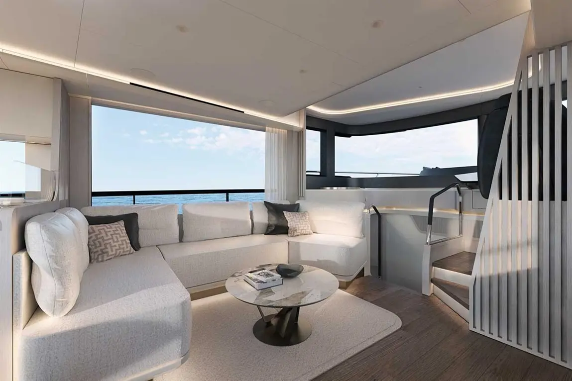 Modern yacht interior featuring a stylish living area with a curved sofa, coffee table, and panoramic ocean views.