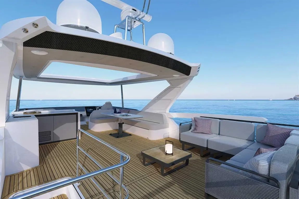 Spacious yacht deck with a seating area, a coffee table, and beautiful sea views under a clear blue sky.