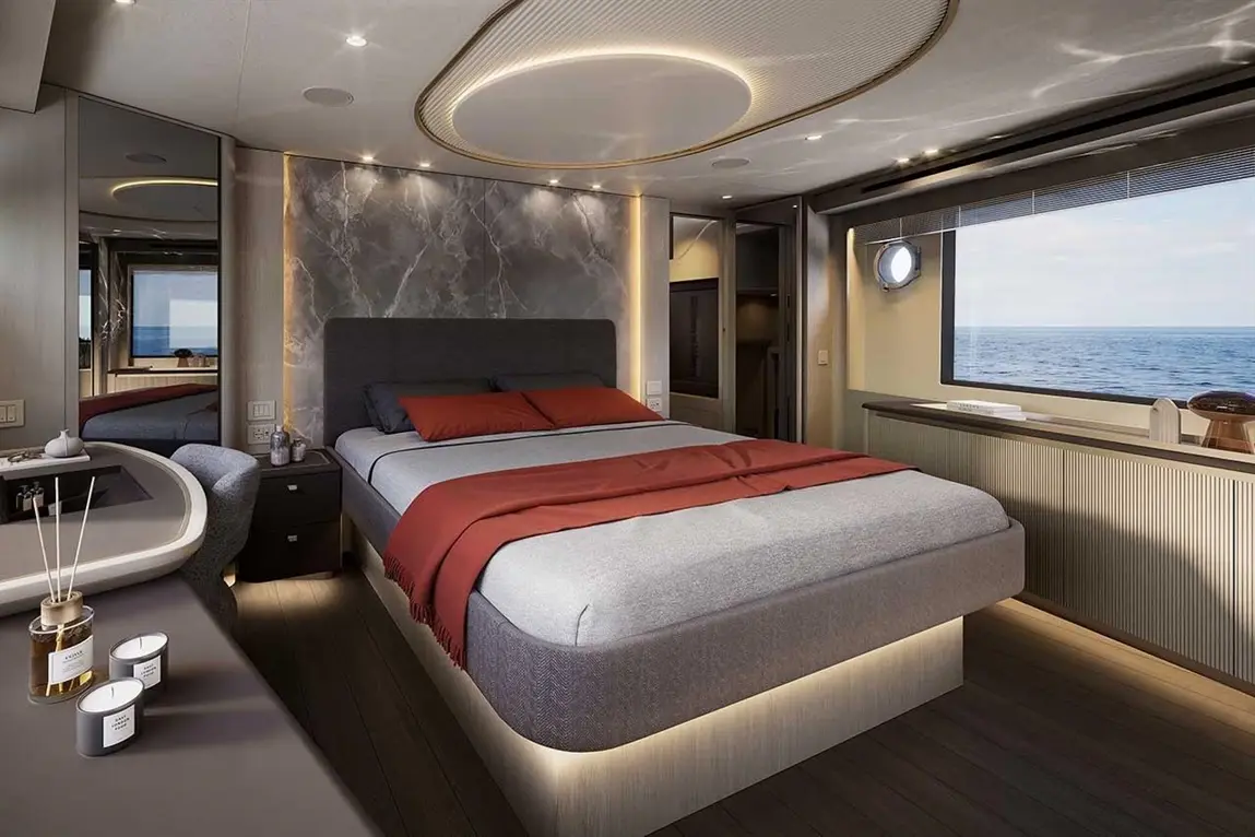 Modern bedroom with a king-size bed, ocean view, ambient lighting, and decorative items on a sleek wooden surface.