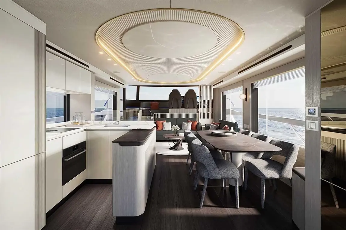 Modern yacht interior featuring a sleek kitchen and dining area, large windows, and contemporary decor with ocean views.