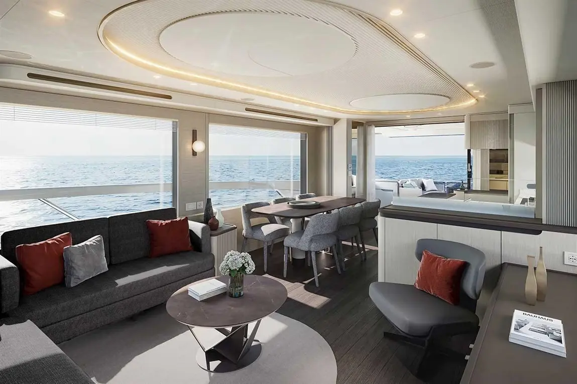 Luxury yacht interior with modern furniture, ocean view, dining area, and stylish decor featuring a coffee table and flowers.