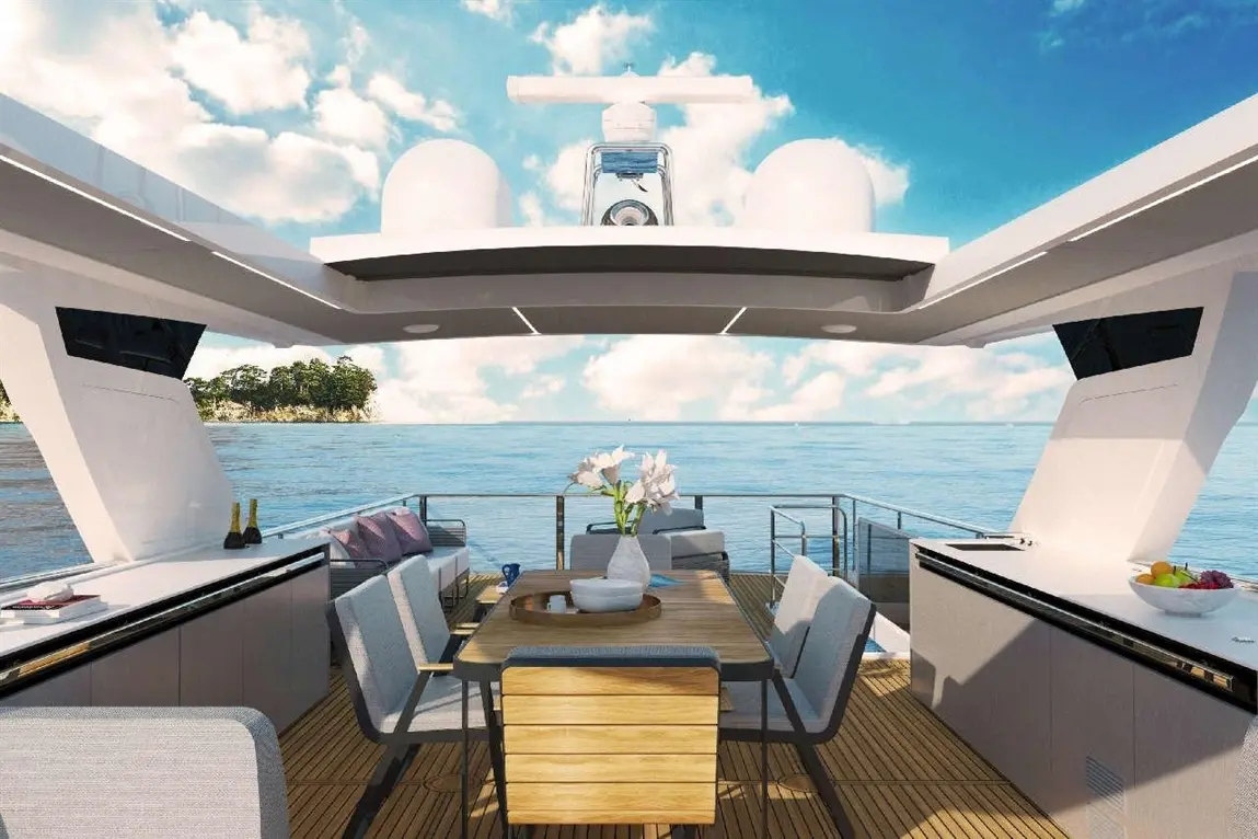 Luxurious yacht deck dining area with a wooden table, grey chairs, flowers, and ocean view under a bright sky.