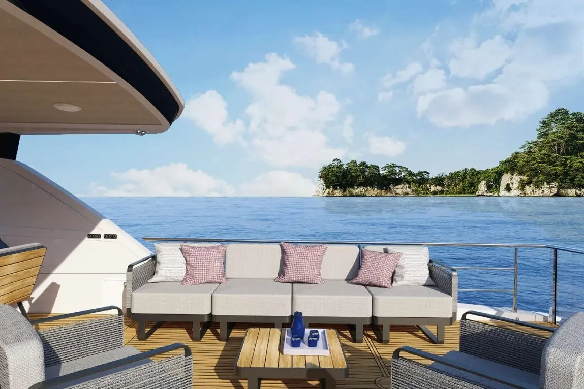 Modern yacht patio with grey sofa, pink cushions, wooden table, and stunning sea view; perfect for relaxation and entertaining.