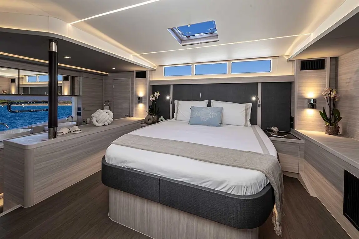 Modern yacht bedroom with a double bed, neutral décor, sea view, and minimalist furnishings. Ideal for relaxing getaways.