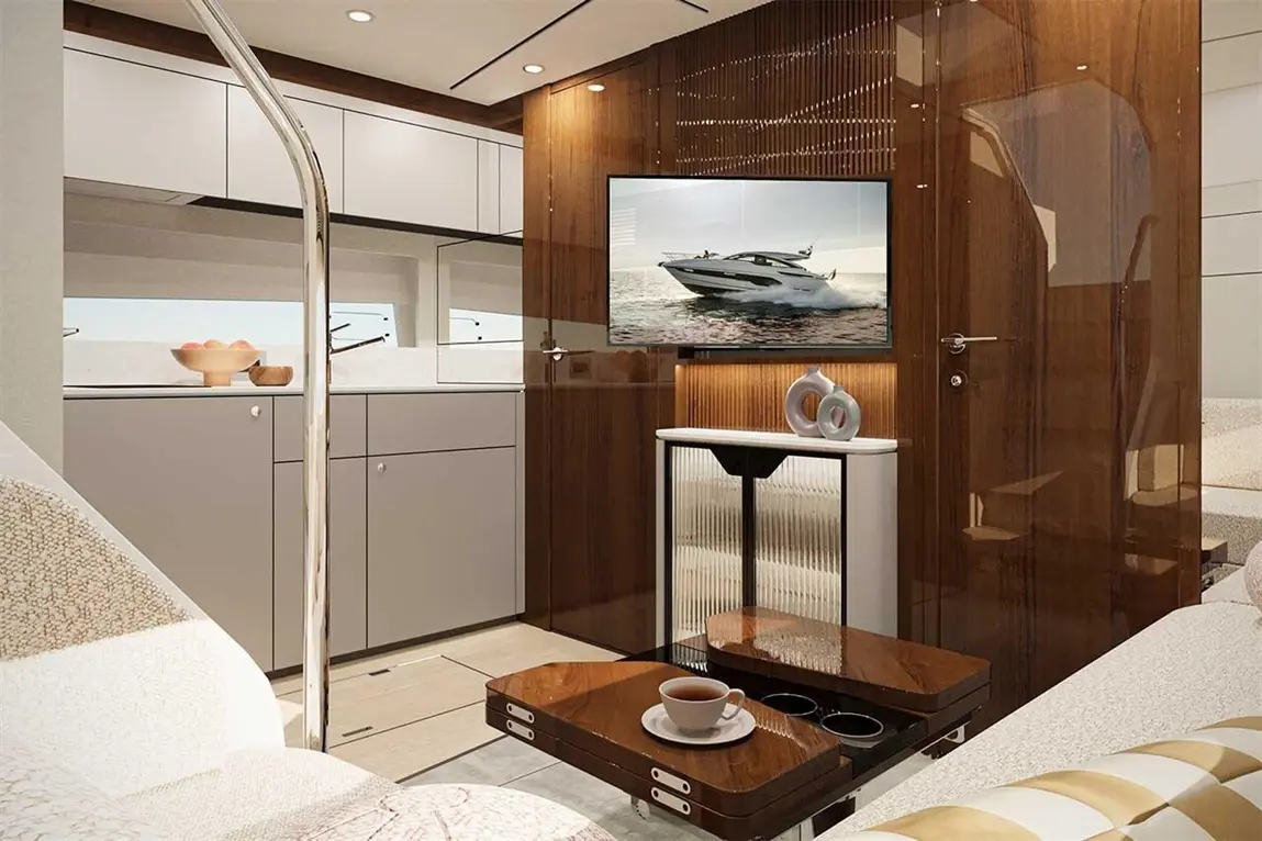 Luxurious boat interior featuring a TV, modern kitchen, coffee table, and stylish seating with large windows.