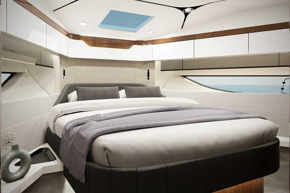 Modern yacht master cabin featuring a bed with grey bedding, sleek cabinetry, a window, and a skylight adding natural light.