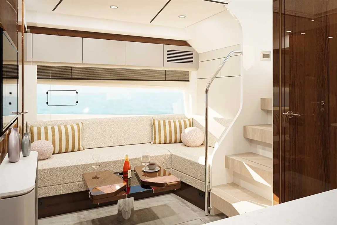 Modern yacht interior featuring a plush seating area, glass coffee table, and a staircase leading to upper levels.