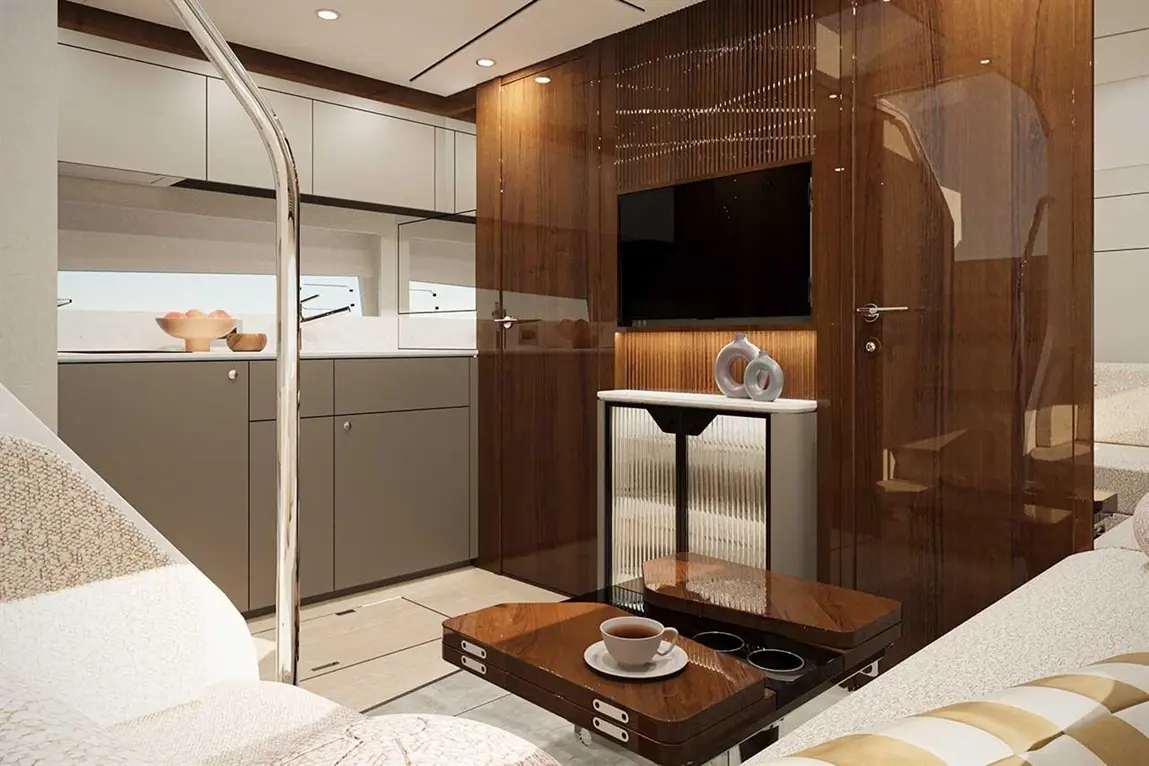 Modern yacht interior featuring a sleek kitchen, wooden accents, and a coffee table with a cup, showcasing luxury design.